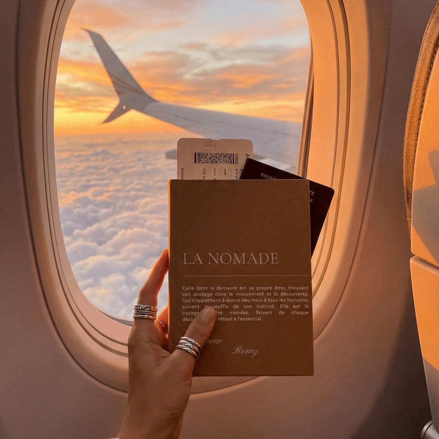 carnet la nomade devant le hublot de l'avion
