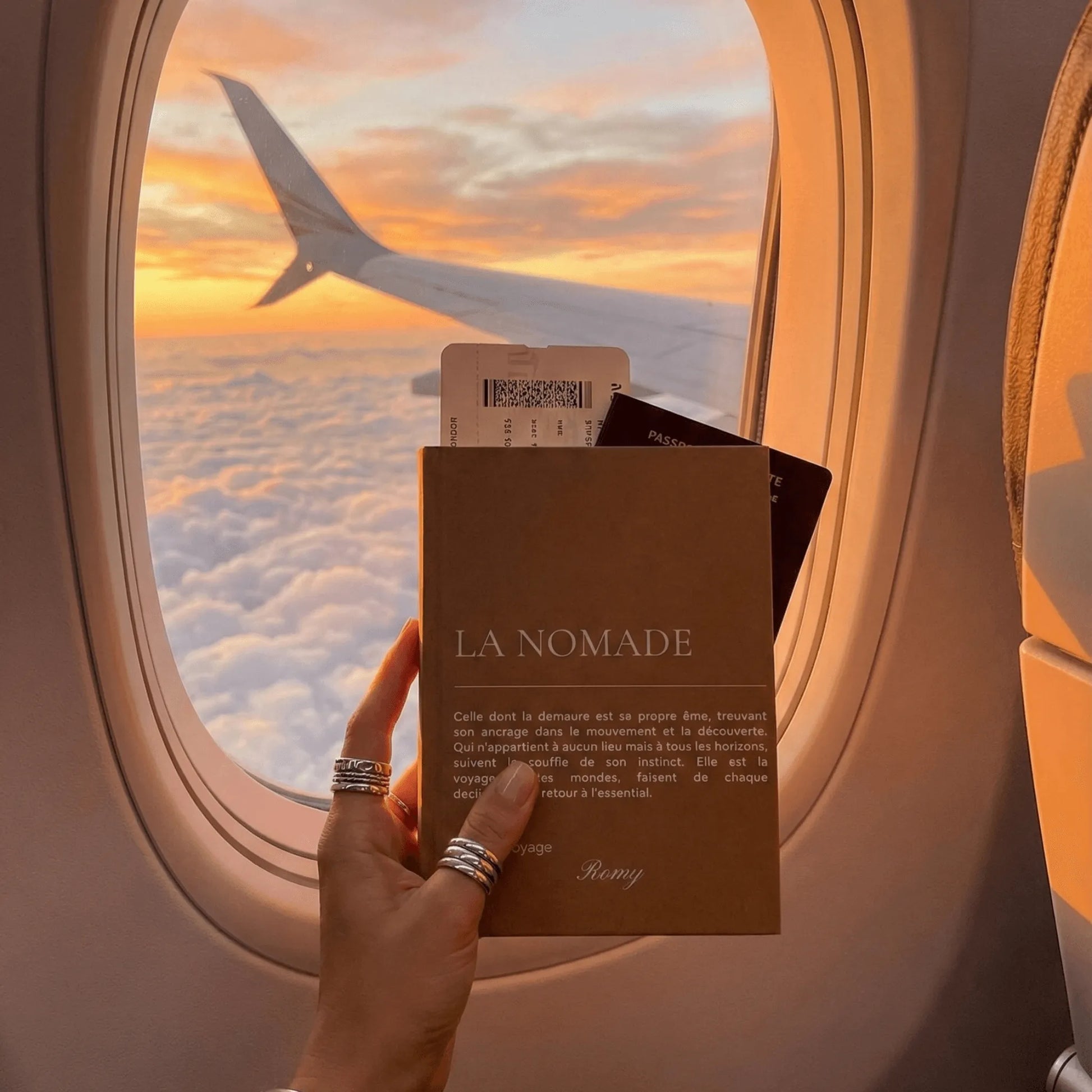carnet la nomade devant le hublot de l'avion