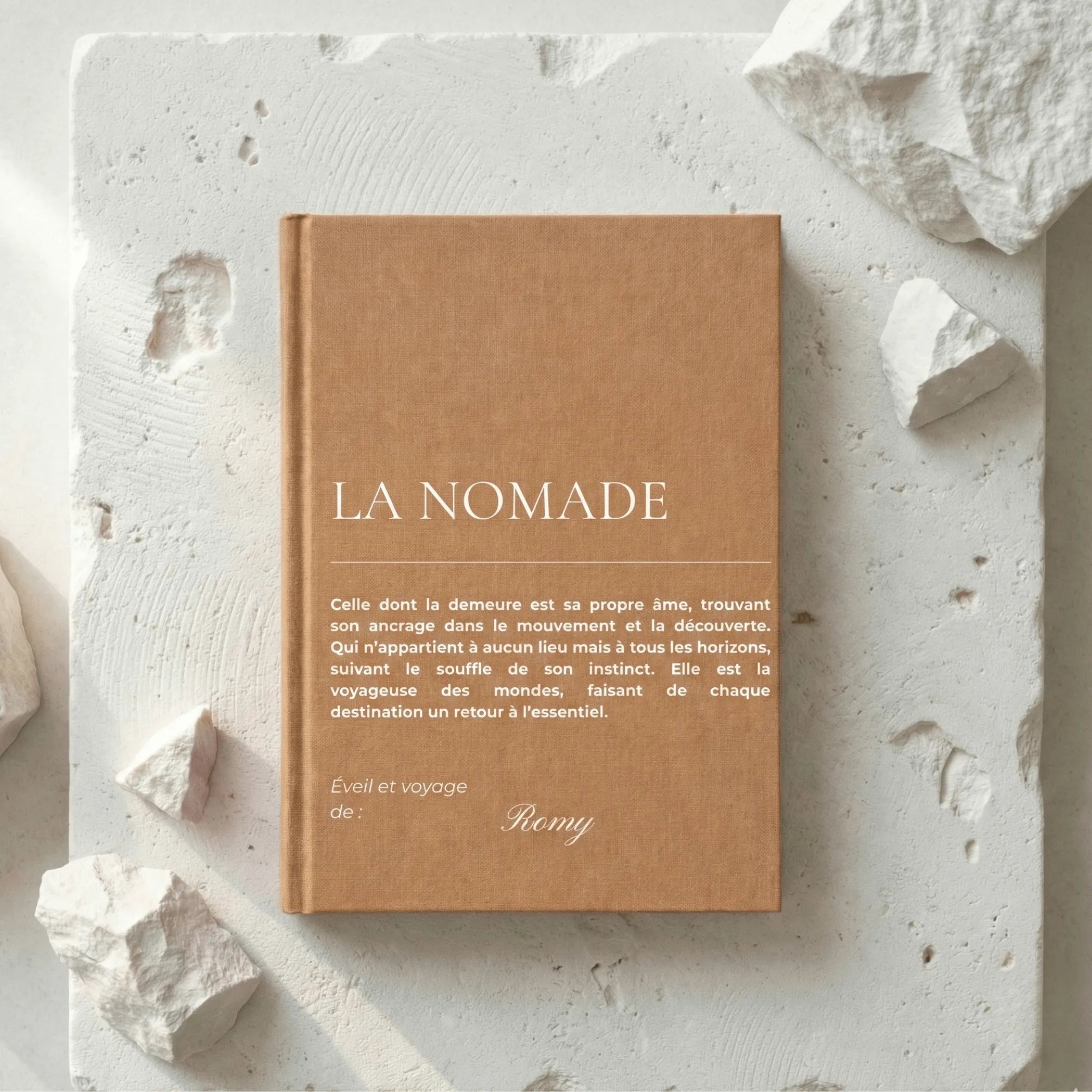 carnet la nomade posé sur un bloc de pierre blanc